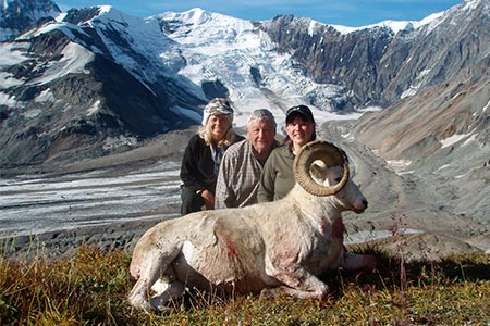 Hunters posing with sheep