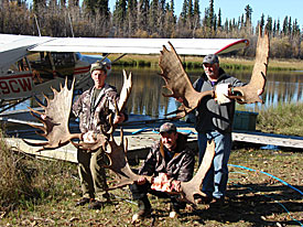 Photo of 3 men holding up antlers
