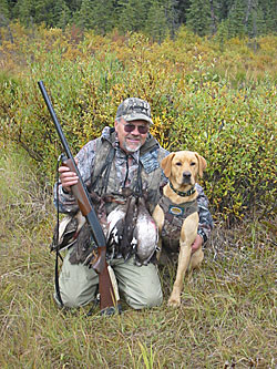 Photo of a man and his dog with ducks.