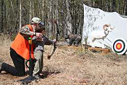 Young archer taking aim at a practice target