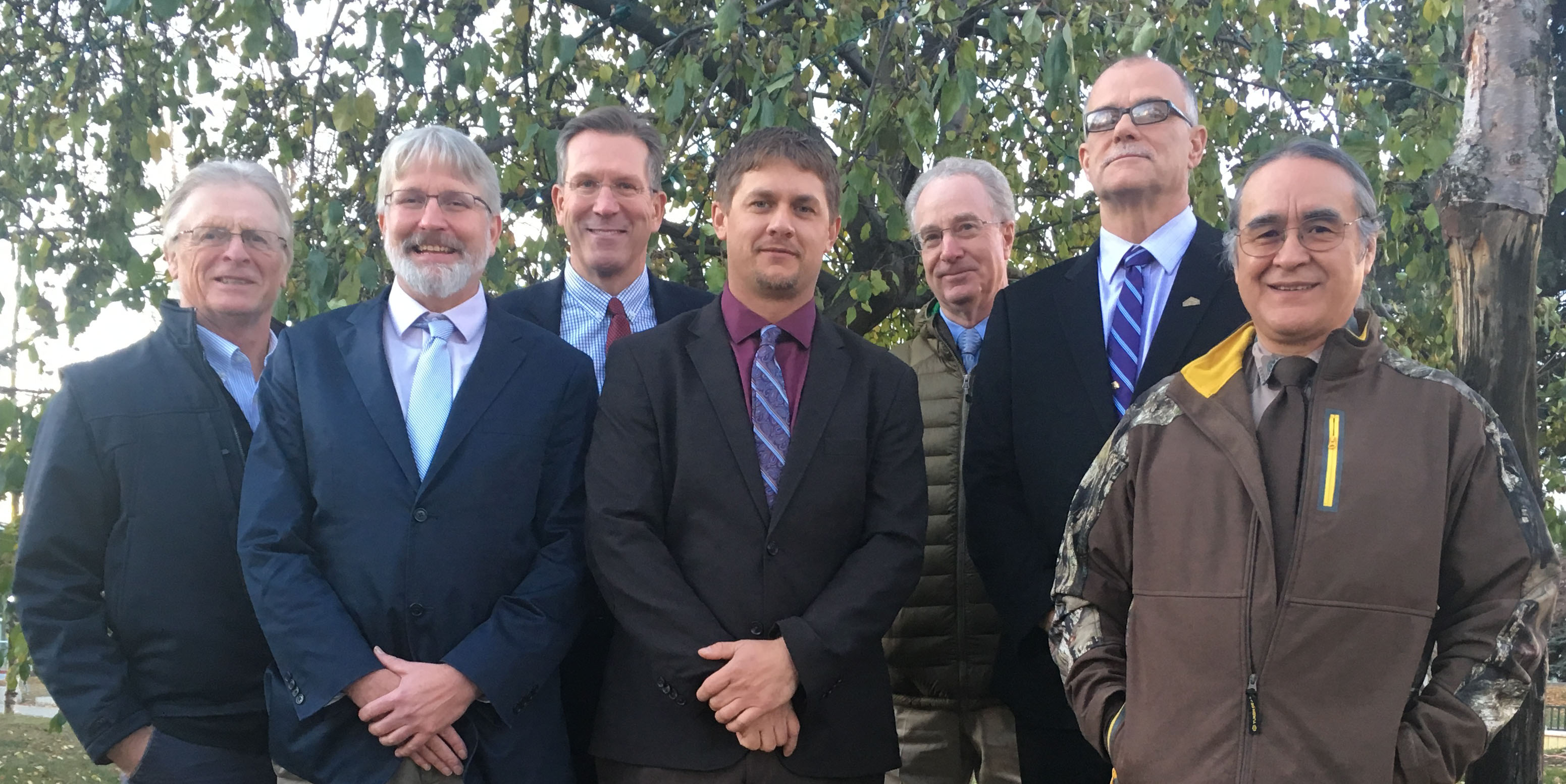 Group photo October 2017; all seven board members standing in front of a tree