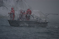 photo of biologists on a boat in glacier bay on a rainy day