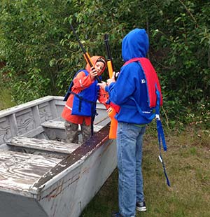 Students in a boat with guns