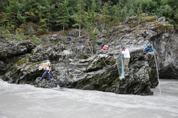 view of personal use fishers holding nets in the water off of a rocky perch