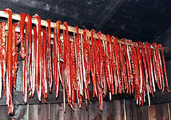 Strips of drying salmon hang on a rack
